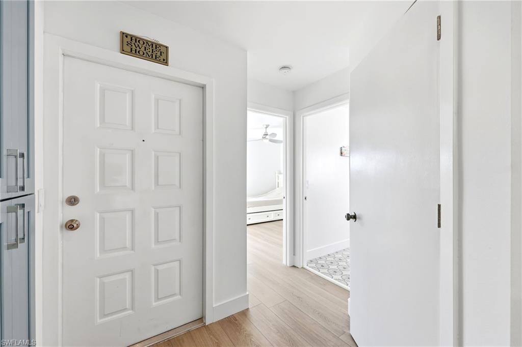7707 Jewel Lane, Unit 201 Naples, FL 34109 - Photo 4 of 31 Corridor with light wood-style flooring and baseboards