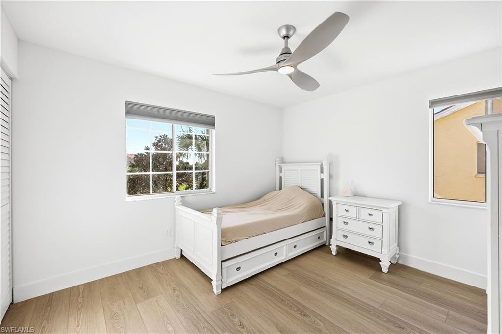 7707 Jewel Lane, Unit 201 Naples, FL 34109 - Photo 5 of 31 Bedroom with light wood-style floors and ceiling fan