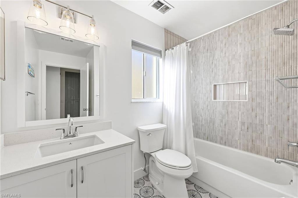 7707 Jewel Lane, Unit 201 Naples, FL 34109 - Photo 7 of 31 Bathroom with vanity, shower / tub combo with curtain, and tile patterned flooring