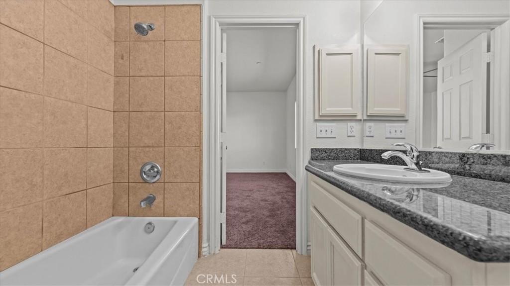 7536 Sunset Road Phelan, CA 92371 - Photo 25 of 40 a bathroom with a granite countertop sink and mirror with bathtub