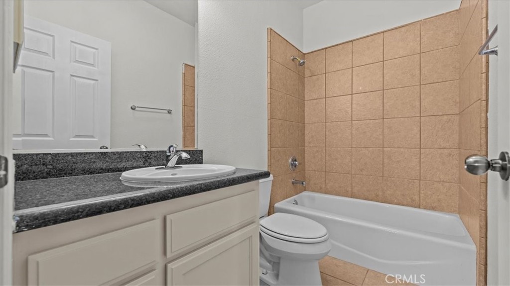 7536 Sunset Road Phelan, CA 92371 - Photo 29 of 40 a bathroom with a granite countertop sink a toilet and bathtub