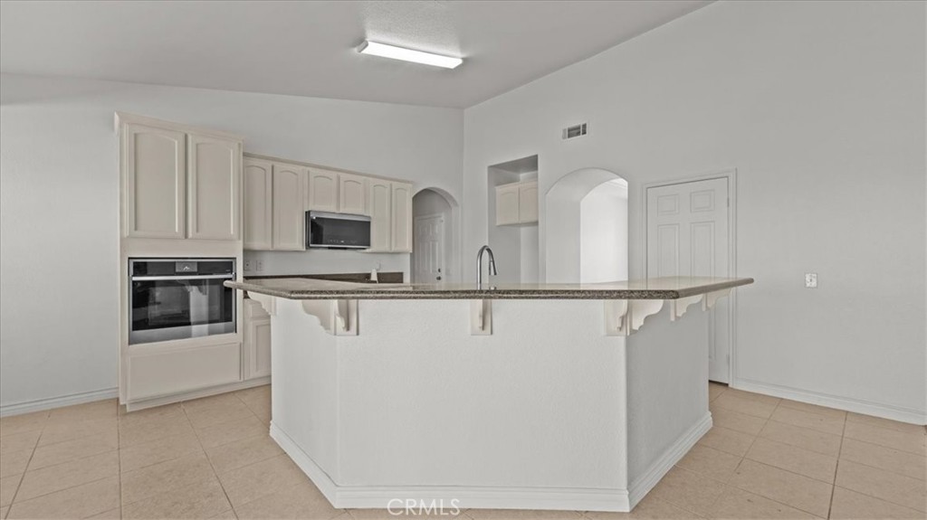 7536 Sunset Road Phelan, CA 92371 - Photo 7 of 40 a kitchen with stainless steel appliances a refrigerator sink and white cabinets