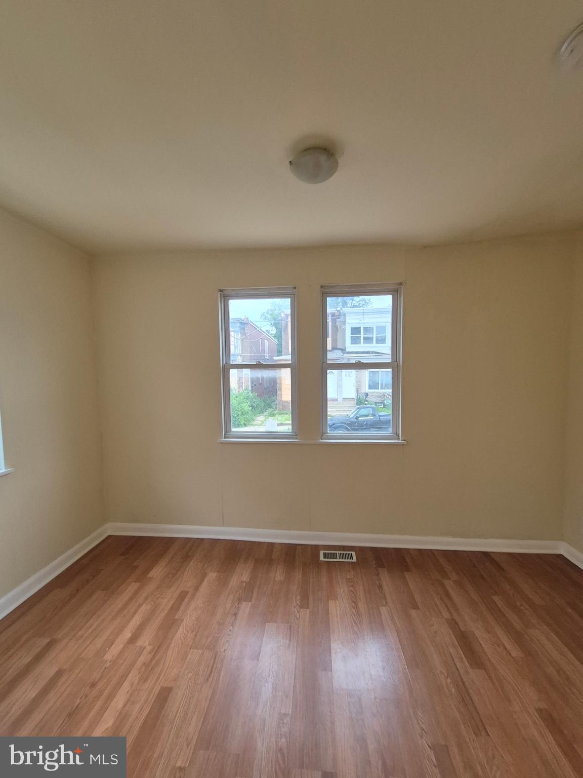 1245 Empire Avenue, Unit 1 Camden, NJ 08103 - Photo 5 of 7 an empty room with wooden floor and windows