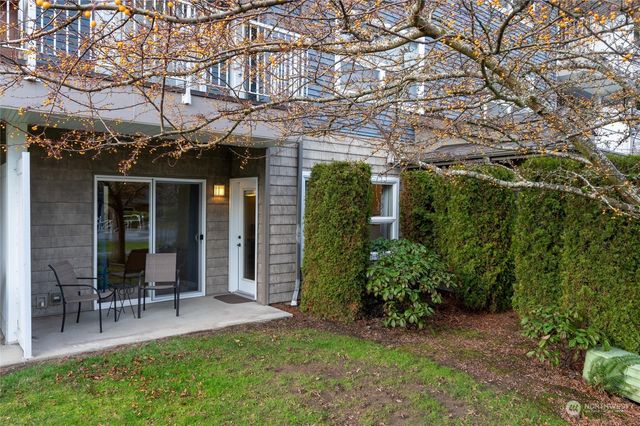 a view of a chair and table in backyard of the house