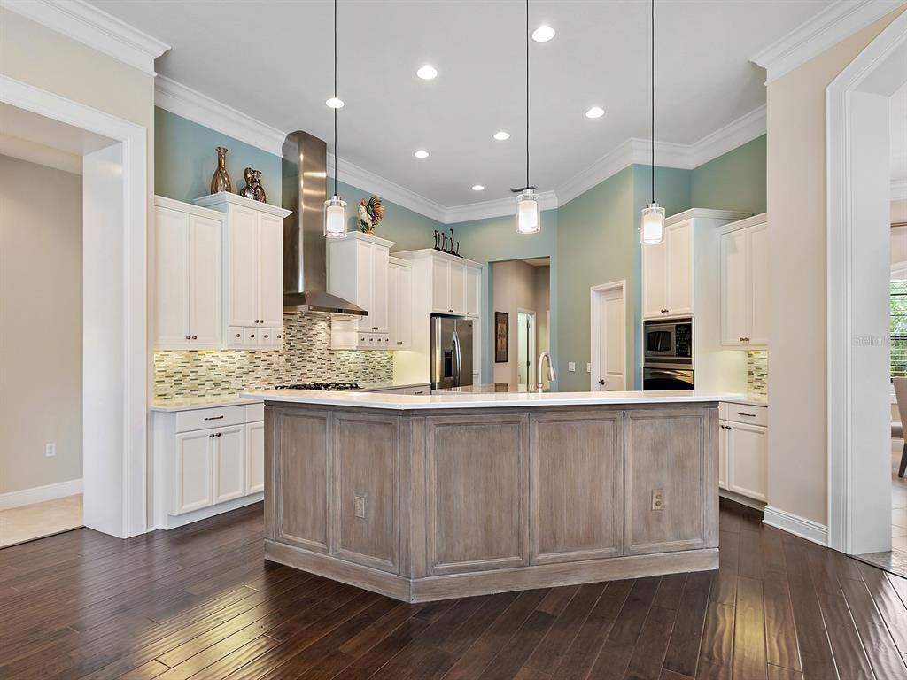 15207 Camargo Place Lakewood Ranch, FL 34202 - Photo 29 of 96 a large kitchen with granite countertop a large counter top space a sink stainless steel appliances and cabinets