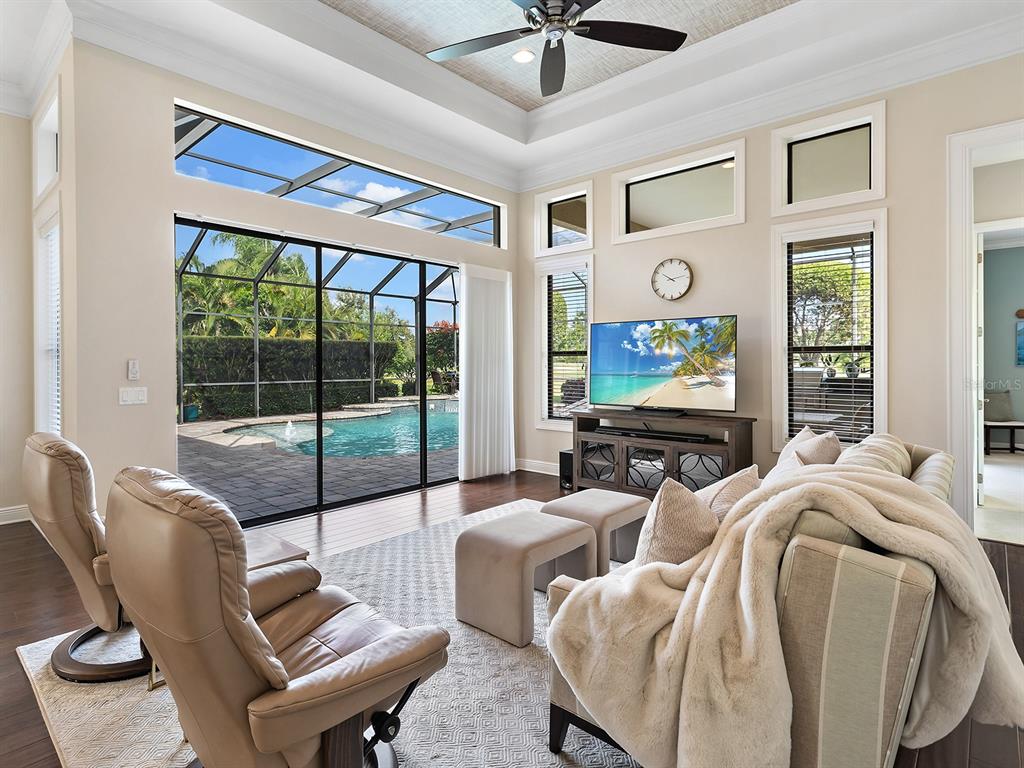 15207 Camargo Place Lakewood Ranch, FL 34202 - Photo 38 of 96 a living room with furniture a floor to ceiling window and a flat screen tv