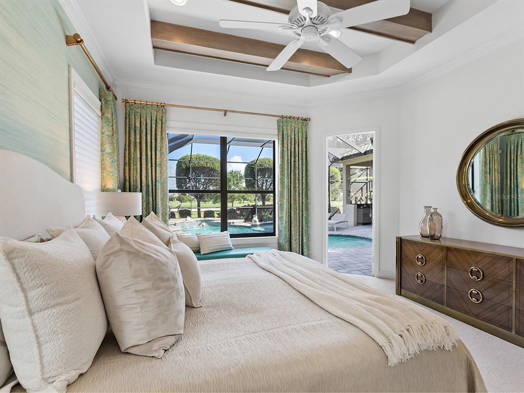 15207 Camargo Place Lakewood Ranch, FL 34202 - Photo 46 of 96 a bedroom with a large bed and a chandelier