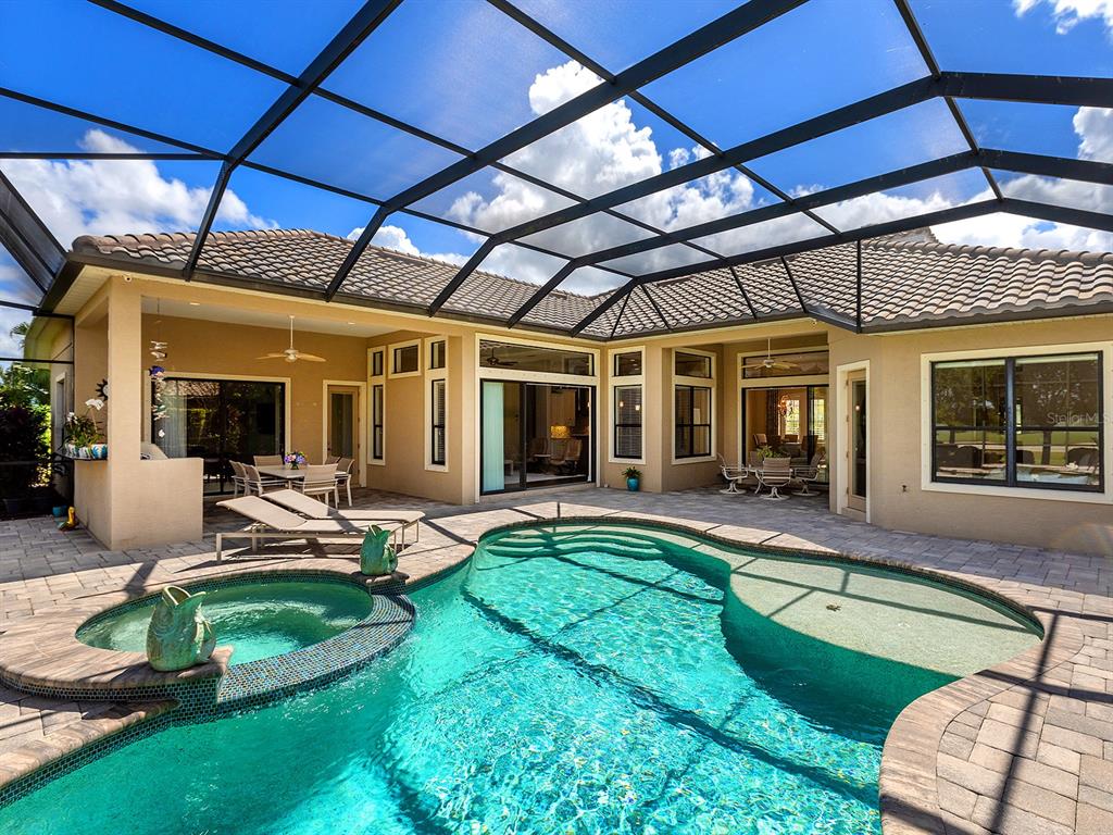 15207 Camargo Place Lakewood Ranch, FL 34202 - Photo 63 of 96 a view of a backyard with table and chairs under an umbrella