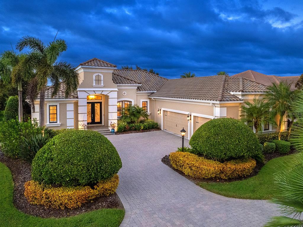 15207 Camargo Place Lakewood Ranch, FL 34202 - Photo 85 of 96 a view of a white house with a big yard and potted plants