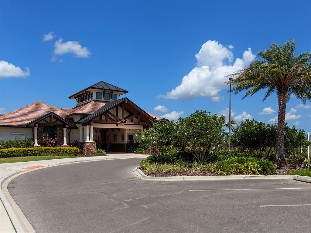 15207 Camargo Place Lakewood Ranch, FL 34202 - Photo 90 of 96 a front view of a house with a yard and potted plants
