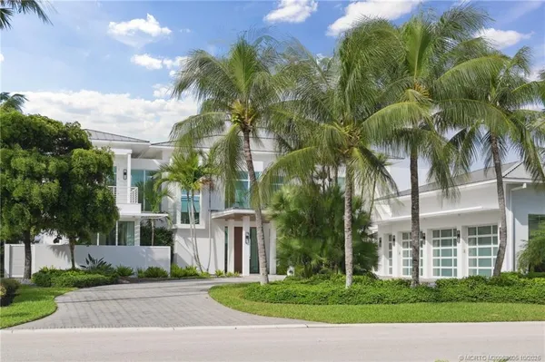a front view of a house with a garden and plants