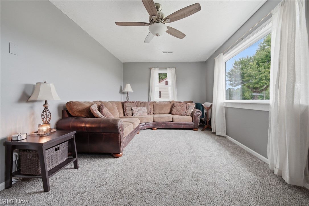 3471 State Rte 5 Newton Falls, OH 44444 - Photo 4 of 31 Spacious living area featuring light gray walls, plush gray carpeting, and a ceiling fan with wood-finish blades