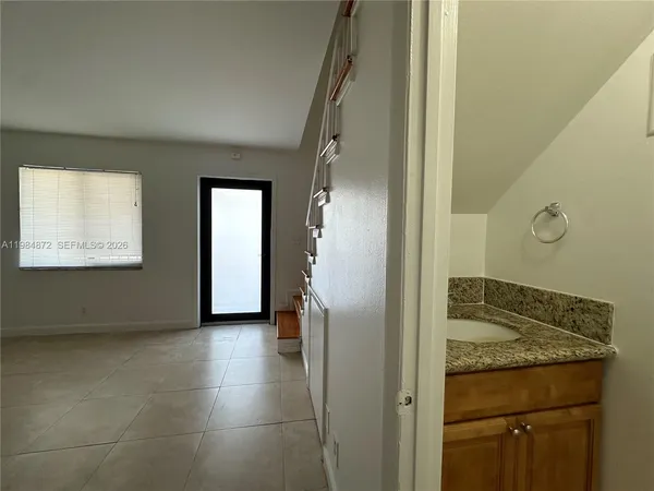 a view of a hallway to rooms and stairs