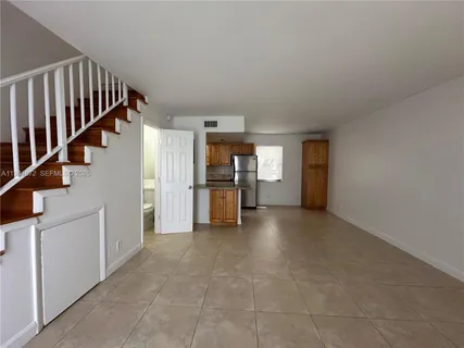 a view of a hallway with an entryway and livingroom