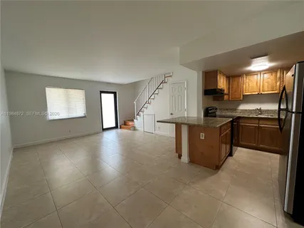 a kitchen with stainless steel appliances granite countertop a stove a sink and a refrigerator