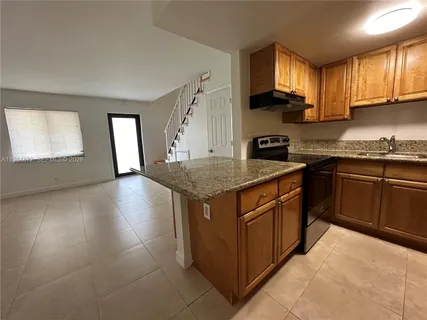 a kitchen with stainless steel appliances granite countertop a sink stove and cabinets