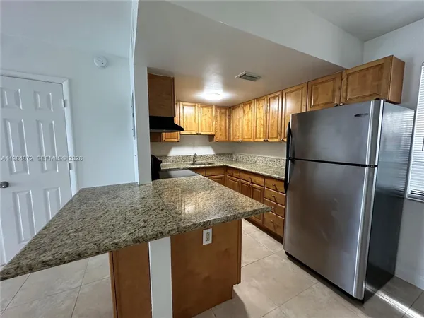 a kitchen with stainless steel appliances granite countertop a refrigerator a sink and a refrigerator