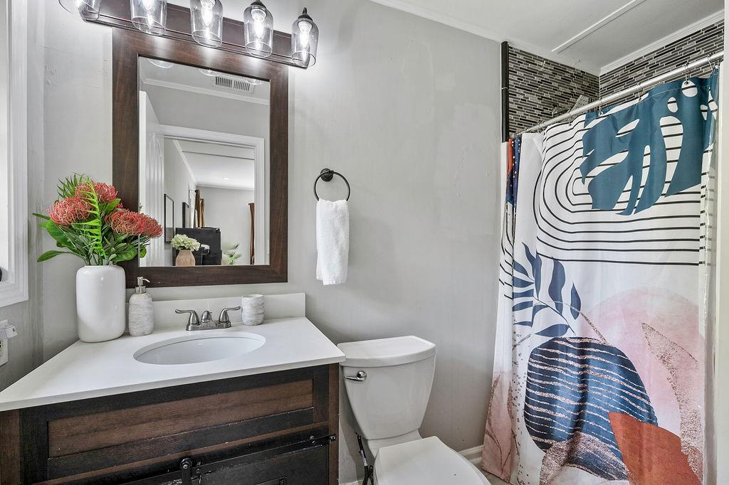 1140 Allgood Road Stone Mountain, GA 30083 - Photo 24 of 25 a bathroom with a sink a toilet and mirror