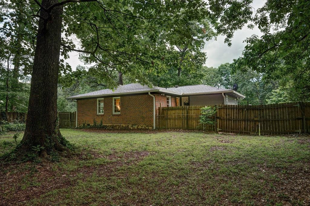 1140 Allgood Road Stone Mountain, GA 30083 - Photo 25 of 25 a view of a small yard in front of a house with large trees