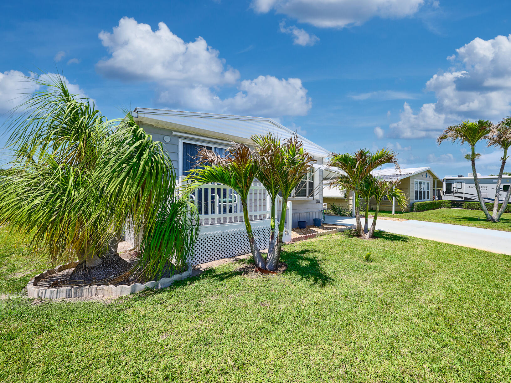 6977 Southeast Delegate Street Hobe Sound, FL 33455 - Photo 5 of 60 a view of a palm trees in front of a house