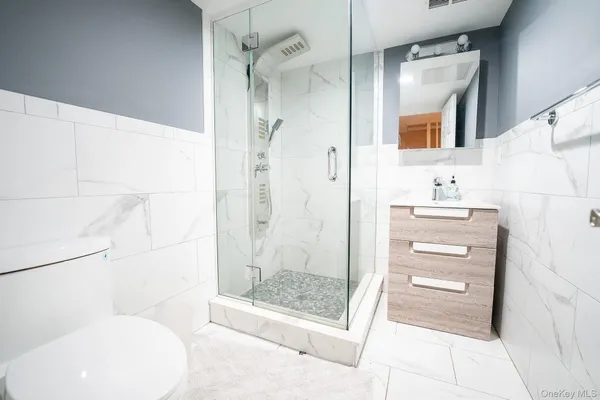 a bathroom with a sink a toilet and shower