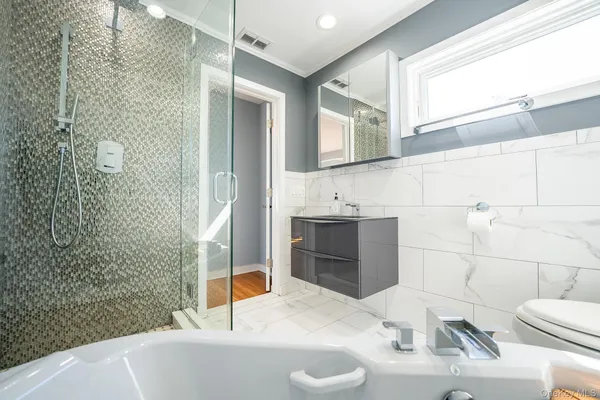 a bathroom with a sink a toilet and shower