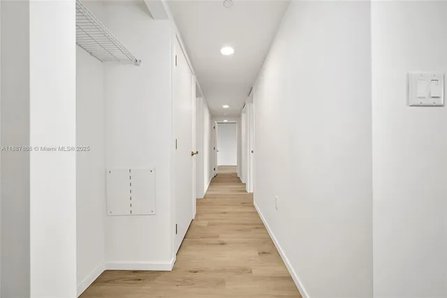 a view of a hallway with wooden floor