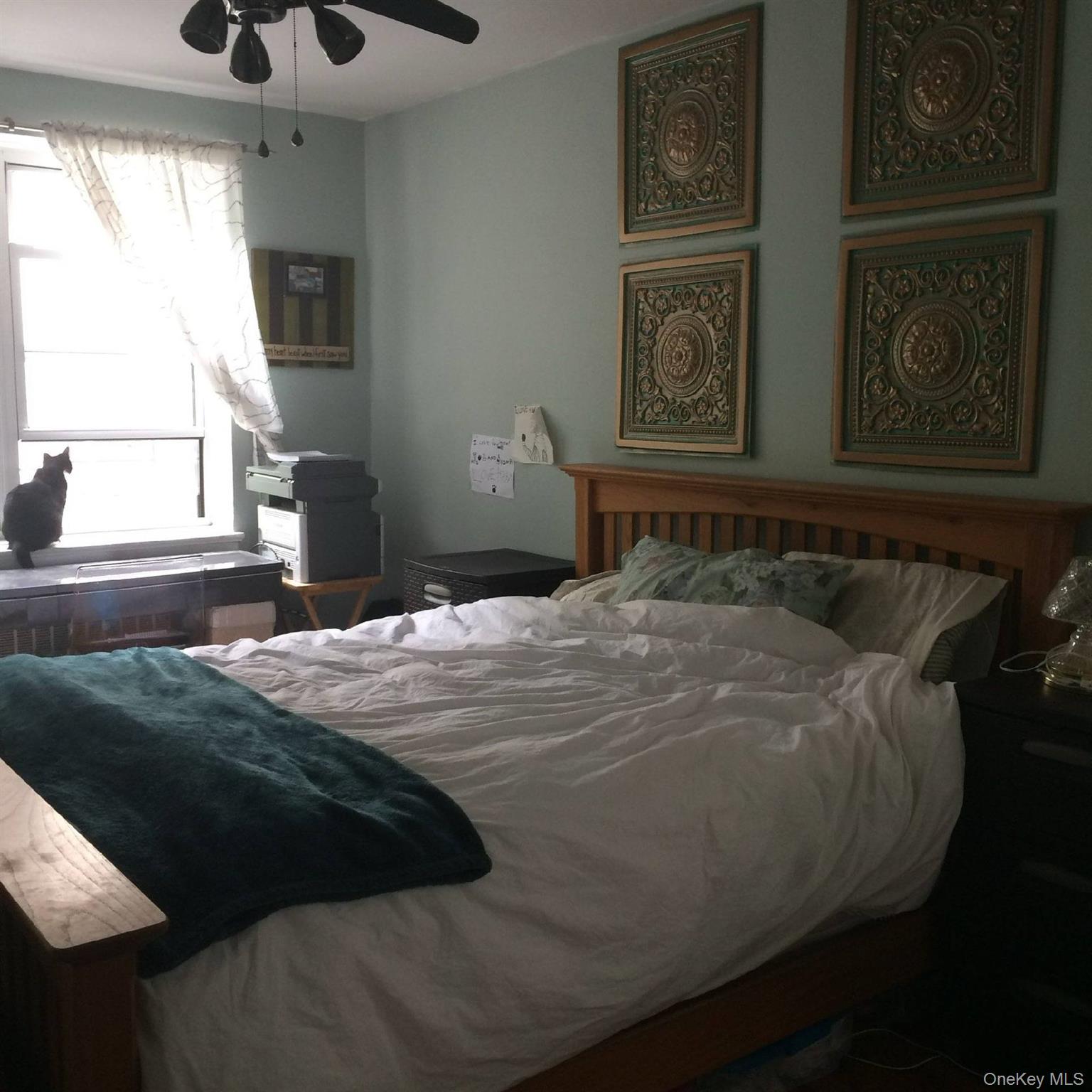 3176 Decatur Avenue, Unit 2H Bronx, NY 10467 - Photo 7 of 11 a bedroom with a bed and painting on the wall