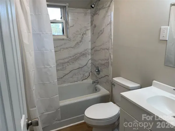 a white toilet and tub next to a window