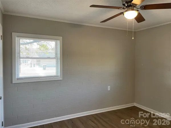an empty room with a window and a fan