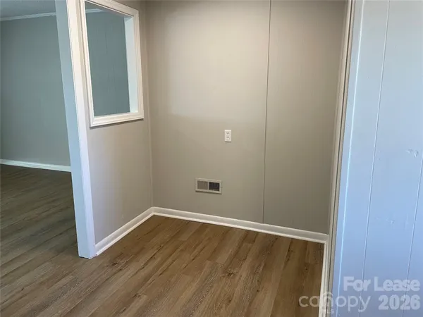 a view of an empty room with wooden floor