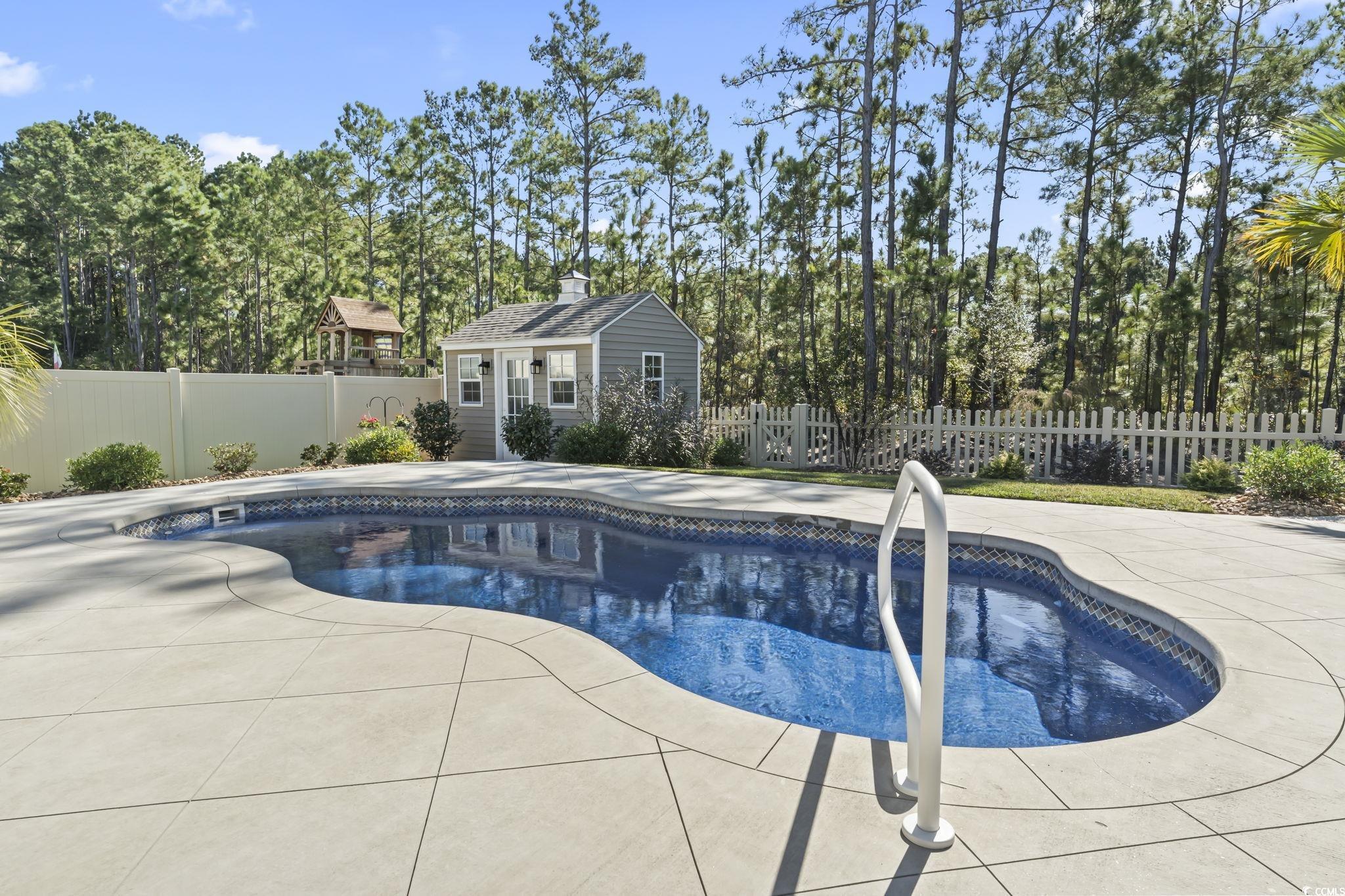 1310 Boswell Court Conway, SC 29526 - Photo 21 of 35 View of swimming pool featuring an outdoor structure, a fenced backyard, a patio, and a storage structure