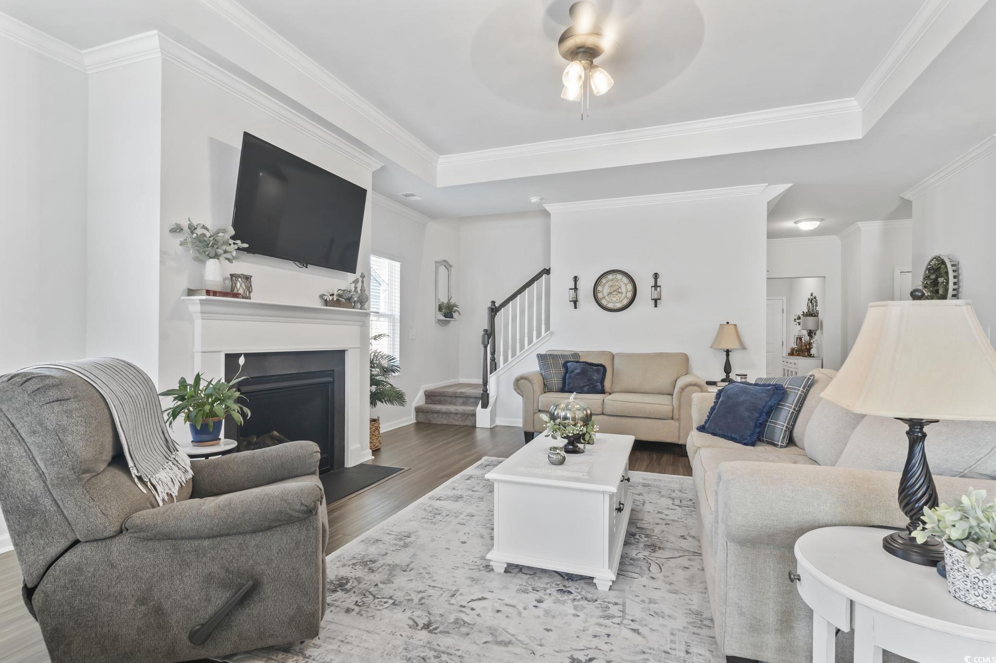 1310 Boswell Court Conway, SC 29526 - Photo 29 of 35 Living area featuring wood finished floors, crown molding, a fireplace, ceiling fan, and stairs