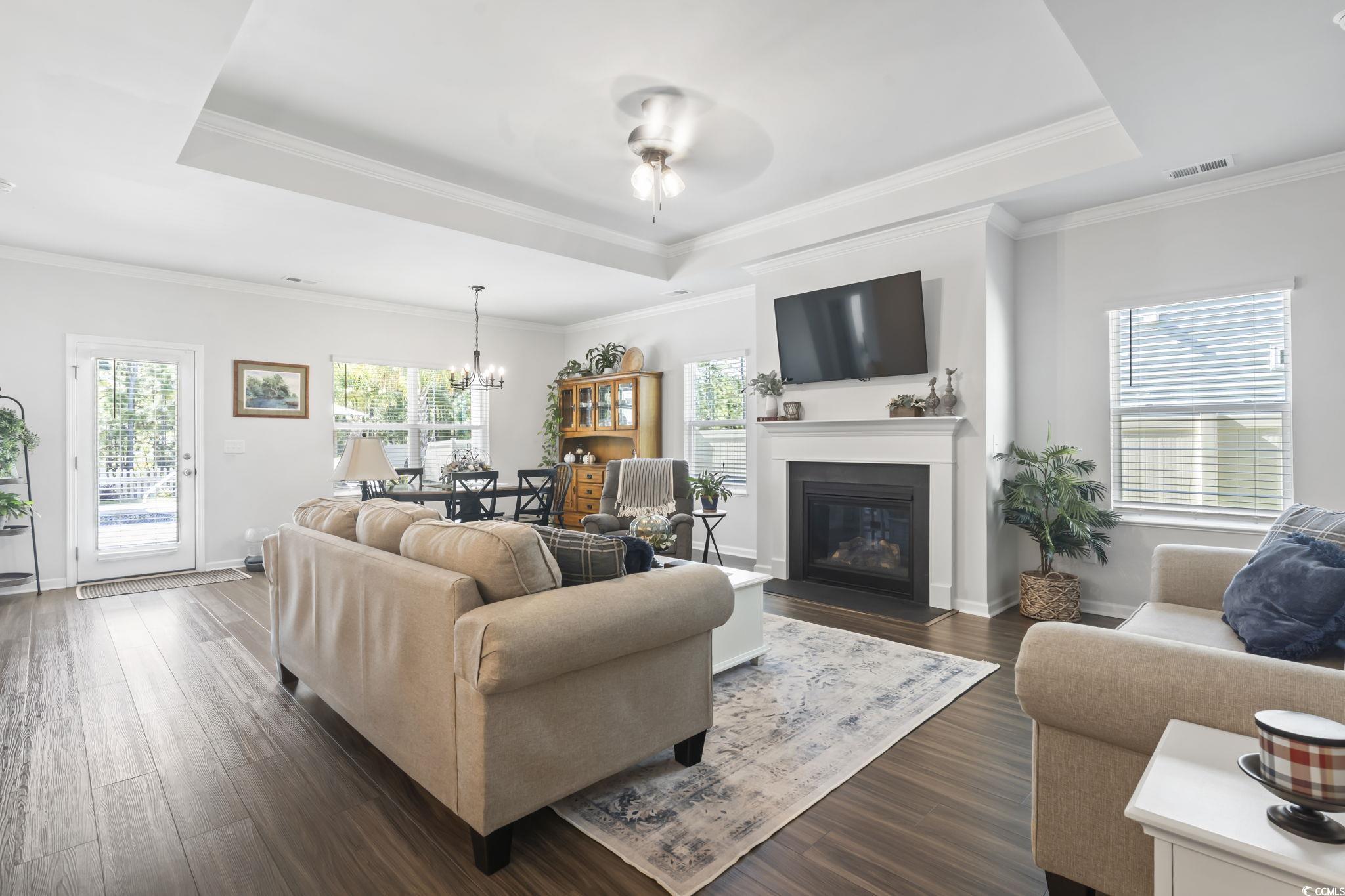 1310 Boswell Court Conway, SC 29526 - Photo 4 of 35 Living room with a tray ceiling, dark wood-type flooring, crown molding, and a chandelier