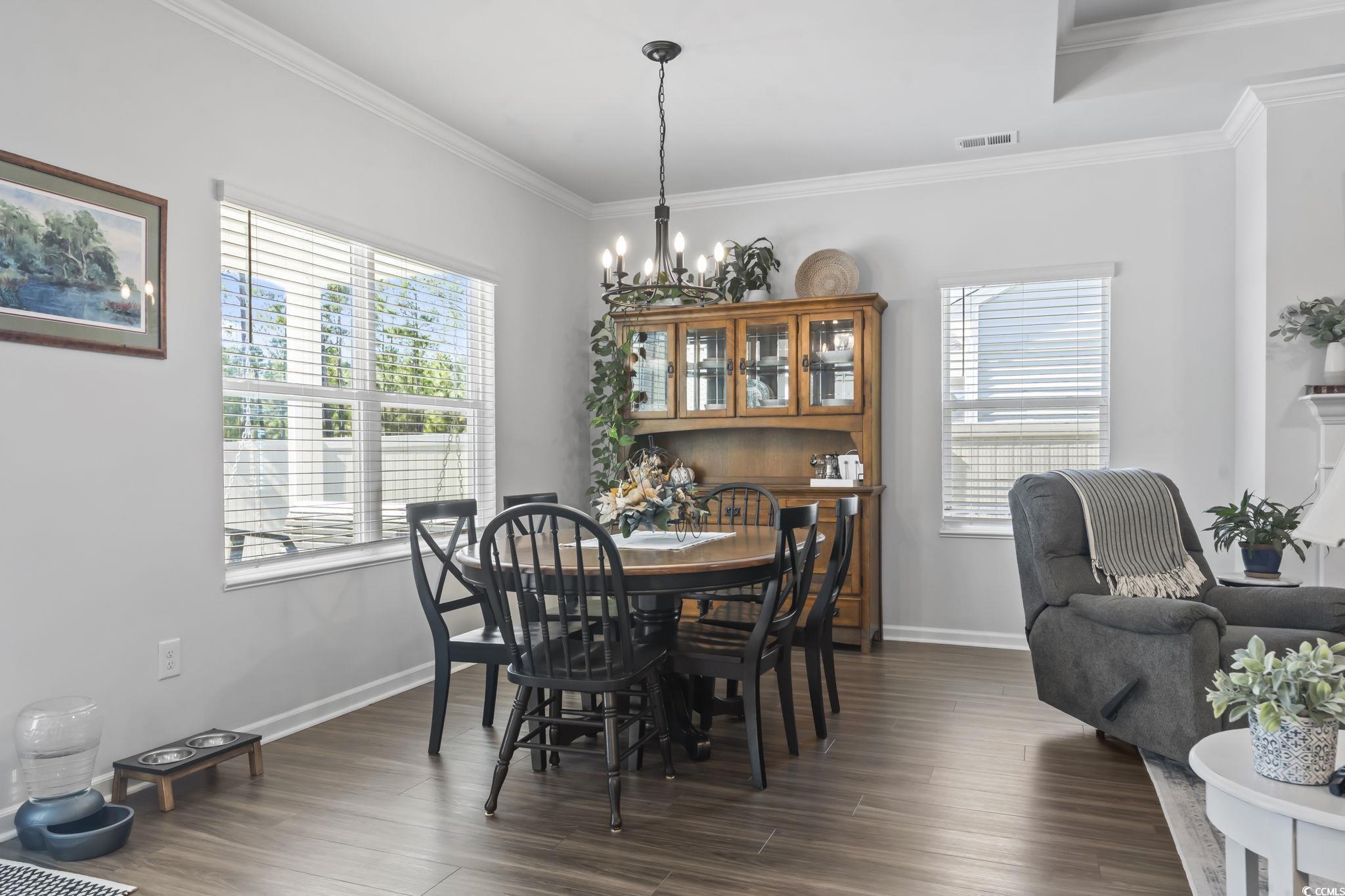 1310 Boswell Court Conway, SC 29526 - Photo 5 of 35 Dining area with crown molding, dark wood-style flooring, and a chandelier