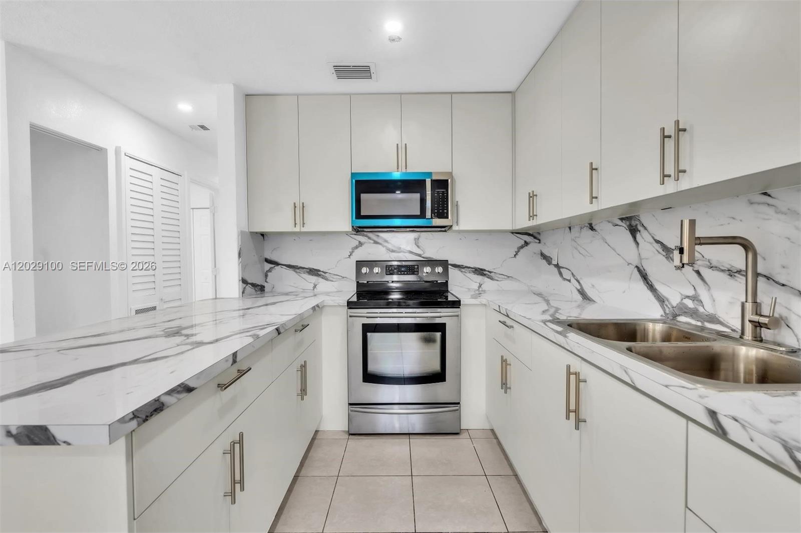 11790 Southwest 34th Street Miami, FL 33175 - Photo 15 of 56 a kitchen with stainless steel appliances granite countertop a sink and a stove