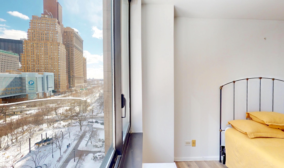 200 Rector Place, Unit 8U Manhattan, NY 10280 - Photo 15 of 25 a view of a bedroom with wooden floor and a sink