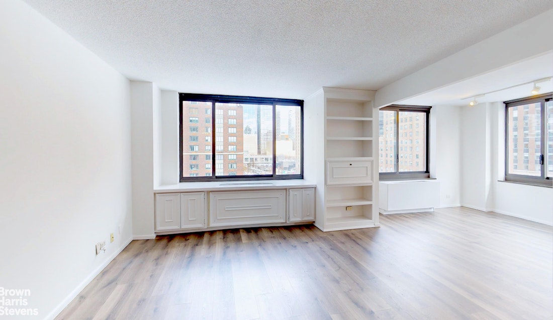 200 Rector Place, Unit 8U Manhattan, NY 10280 - Photo 2 of 25 an empty room with wooden floor and windows