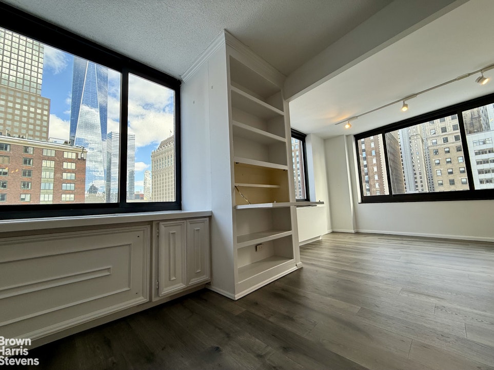 200 Rector Place, Unit 8U Manhattan, NY 10280 - Photo 3 of 25 a view of an empty room with a window and wooden floor