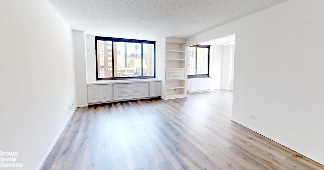 200 Rector Place, Unit 8U Manhattan, NY 10280 - Photo 7 of 25 an empty room with wooden floor and windows