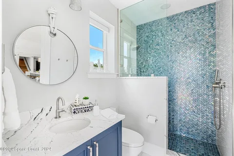 a bathroom with a granite countertop sink mirror vanity and toilet