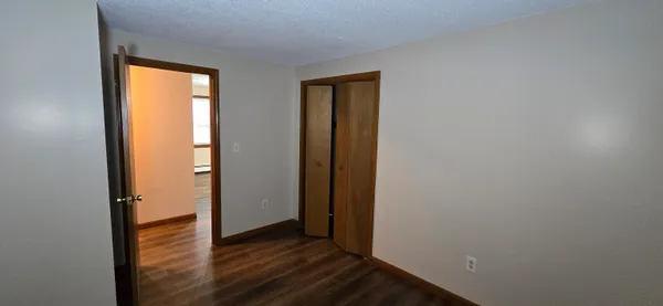 an empty room with wooden floor and a window