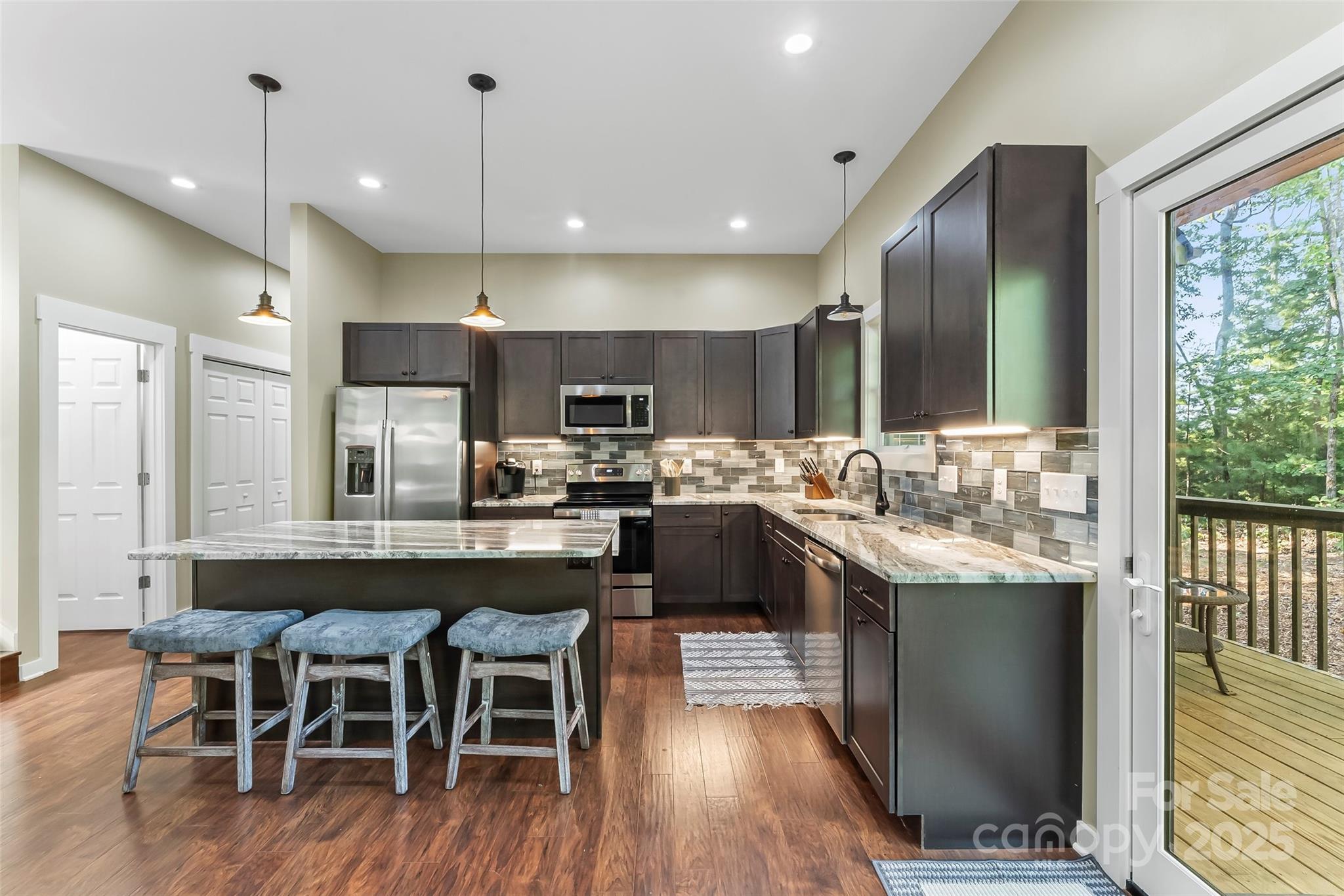 90 Clinchfield Gap Road Marion, NC 28752 - Photo 11 of 42 a kitchen with stainless steel appliances granite countertop a kitchen island hardwood floor sink stove dining table and chairs