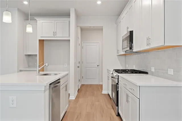 a kitchen with stainless steel appliances granite countertop a sink stove and refrigerator