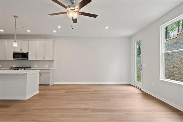 a view of kitchen with stainless steel appliances granite countertop cabinets and wooden floor