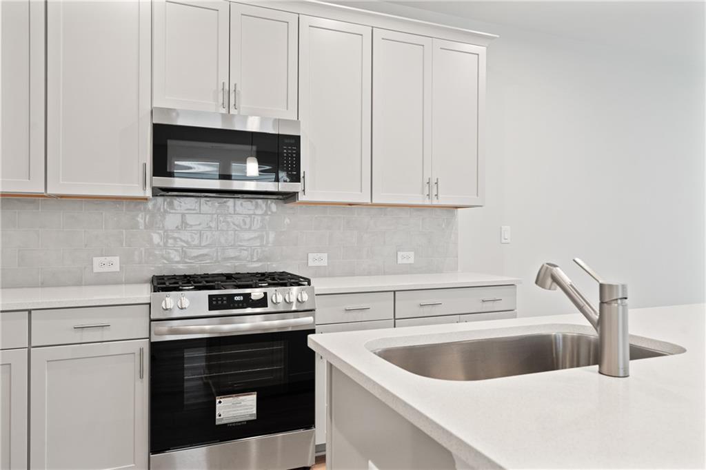 710 Smokey Quartz Way Kennesaw, GA 30144 - Photo 18 of 31 a kitchen with a sink and a stove top oven