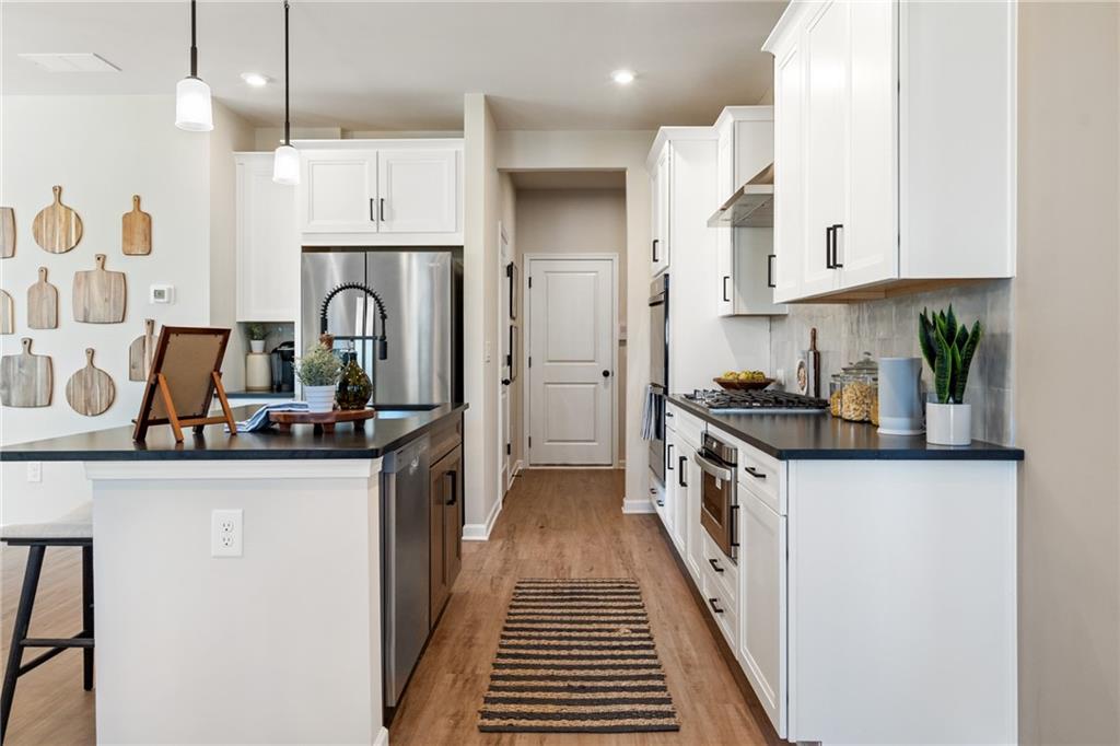 710 Smokey Quartz Way Kennesaw, GA 30144 - Photo 48 of 76 a kitchen with stainless steel appliances a sink stove and cabinets