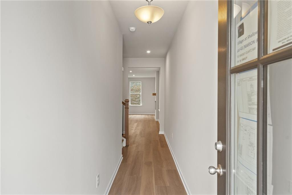 710 Smokey Quartz Way Kennesaw, GA 30144 - Photo 5 of 31 a view of a hallway with wooden floor and a bathroom
