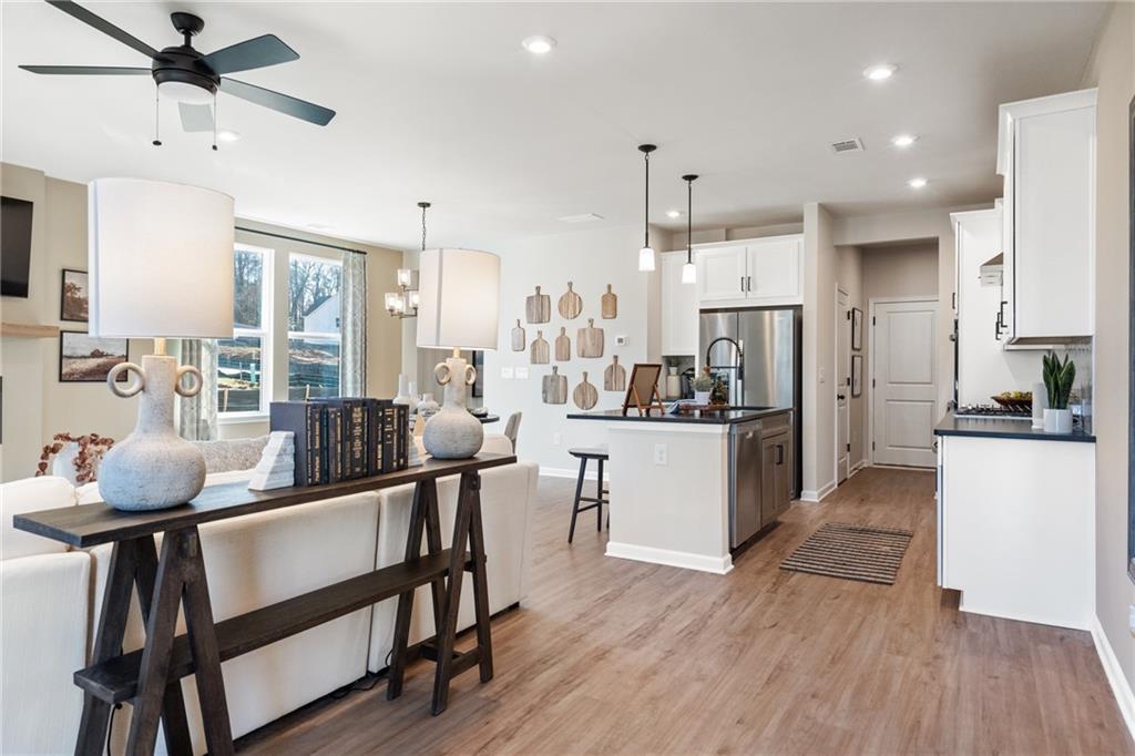 710 Smokey Quartz Way Kennesaw, GA 30144 - Photo 55 of 76 a kitchen with stainless steel appliances kitchen island granite countertop a stove a refrigerator a oven a sink with island and chairs with wooden floor