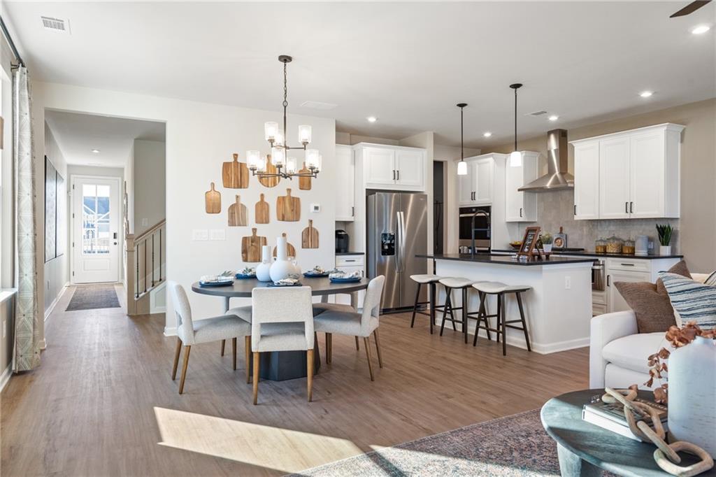 710 Smokey Quartz Way Kennesaw, GA 30144 - Photo 56 of 76 a view of a dining room and livingroom with furniture wooden floor a chandelier
